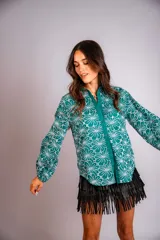 Camisa celeste con estampado de flores blancas, corte clásico, cuello camisero y mangas largas abullonadas.