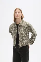 Chaqueta corta de jean con estampado animal print en tonos beige y gris, cuello camisero, cierre frontal con cremallera, bolsillos de parche en el pecho y corte entallado.
