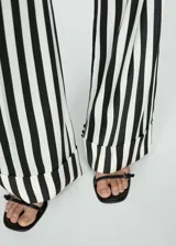 Pantalón largo de mujer con estampado de rayas verticales en blanco y negro, corte recto y bajo con vuelta.