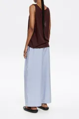 Pantalón de pinzas con largo tobillero a rayas verticales celestes y blancas. Cinturilla elástica, cierre frontal con botón y bolsillos diagonales. Vuelta en el bajo de la pierna.