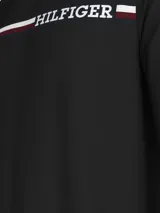 Remera negra de manga larga Tommy Hilfiger, de corte regular, con cuello redondo y logo Hilfiger estampado en el pecho sobre una franja horizontal con los colores característicos de la marca.
