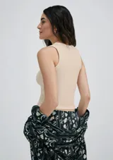 Musculosa marrón de tela acanalada con cuello redondo y sisas anchas.