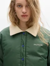 Campera verde con cuello beige de pana, largo a la cadera, con elástico inferior para ceñir a gusto. Cierre por botones a presión, bolsillos frontales y forro de cuerpo estampado de algodón.