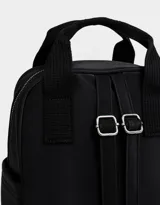 Mochila negra de cuerina con doble asa corta de mano con textura, correas regulables, cierre superior, bolsillo frontal con cierre, bolsillos laterales y tag en relieve.