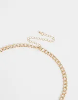 Collar corto dorado con cadena de eslabones y dijes de corazones, cruces y flor.