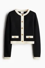 Saco corto negro de punto fino suave con cuello redondo, botones metálicos dorados y bolsillos insertados decorativos con botón adelante.