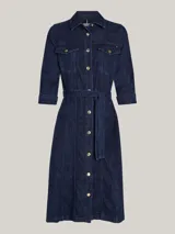 Vestido camisero midi de denim azul oscuro, con cuello clásico, manga tres cuartos y cierre frontal con botones. Incluye cinturón de la misma tela para ajustar a la cintura y dos bolsillos de parche con solapa en el pecho.