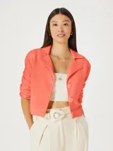 Blazer cropped color naranja con solapas y cierre frontal con botones.