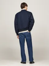 Campera bomber azul marino Tommy Hilfiger, con cuello, puños y bajo de punto canalé. Cierre frontal con cremallera, dos bolsillos laterales con botón a presión y logo bordado en el pecho.