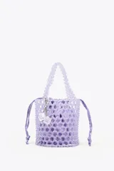 Bolso mini saca cilíndrica con cuerpo de cuentas transparentes y bolsita interior de tela satinada color lila con cierre fruncido. Incluye charm extraíble con forma de cubo.