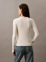 Remera blanca de punto acanalado con cuello en V y mangas largas. Corte ajustado al cuerpo.