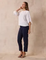 Blusa de gasa color blanco con estampado de hojas verdes, de mangas 3/4 abullonadas con puños elásticos.