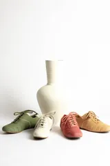 Zapatillas acordonadas color beige con detalles en blanco.