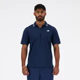 Chomba de piqué azul marino con cierre parcial con cremallera, cuello tipo polo con ribete doble blanco, mangas cortas y logo de New Balance bordado en blanco en el pecho.