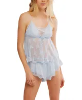 Conjunto de pijama de dos piezas, compuesto por un camisón babydoll y un short. Ambas prendas son de color celeste pálido, confeccionadas en tejido transparente con bordado floral y detalles de encaje en los bordes. El camisón tiene tirantes finos y un lazo ajustable en el centro del busto.