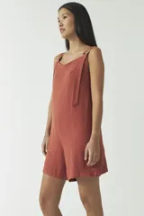 Mono corto estilo jardinero color ladrillo, con breteles regulables y hebillas metálicas.