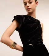 Pulsera dorada con elástico y textura de escamas sobrepuestas.