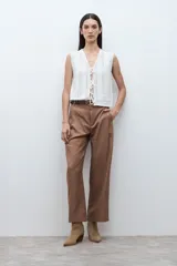 Pantalón de vestir color marrón, de tiro alto, con pinzas frontales y corte recto/holgado.