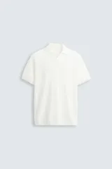 Polo regular fit de punto color blanco, tejido en hilatura de algodón. Cuello solapa con abertura frontal, manga corta y acabados en rib.