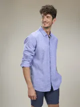 Camisa verde militar de manga larga, confeccionada en mezcla de lino y algodón. Tiene cuello clásico, cierre con botones y un bolsillo en el pecho.