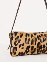 Mini cartera plateada de cuero con correa fina del mismo material y aplique metálico JCH en el frente.