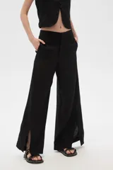 Pantalón negro ancho de lino y viscosa, de tiro alto y corte palazzo con aberturas en el ruedo.