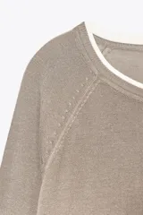 Jersey color visón de tejido de punto con efecto doble en cuello y puños. De corte recto, cuello redondo y manga larga.
