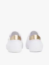 Zapatillas Tommy Hilfiger blancas de lona, con suela de goma vulcanizada, talón metalizado color dorado y logo de la marca bordado en el lateral.