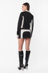 Minifalda deportiva gris con recortes laterales en negro y logo estampado en la parte trasera. Cierre invisible en el lateral.