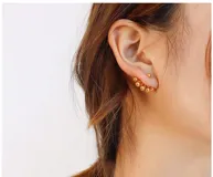 Aros dorados con forma de abanico, con cuentas redondas de diferentes tamaños.
