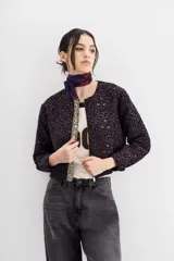 Campera bomber con estampado animal print, cuello redondo y corte a la cintura. Presenta detalle de cartera bordada en piedras y strass.