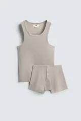 Conjunto de pijama color gris compuesto por una camiseta sin mangas de corte ajustado y un bóxer corto con cintura elástica y botones.