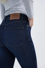 Jean de denim azul marino con elastano, corte slim hasta las rodillas y flare en los ruedos.