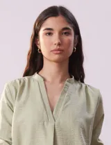 Blusa color beige de poliéster con escote en V y mangas 3/4 regulables con presilla y botón.