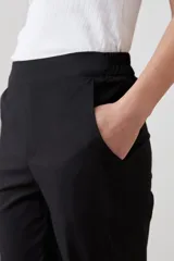 Pantalón de vestir negro, de corte recto, con bolsillos laterales y traseros.