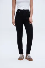 Pantalón de jean negro de tiro medio con calce ajustado desde la cintura hasta los tobillos.