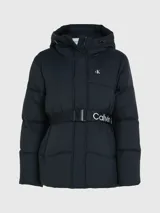 Campera puffer negra de nailon con capucha y cinturón con hebilla. Tiene cierre de cremallera y botón de presión, bolsillos en la cintura y logo monograma de Calvin Klein estampado en el pecho.