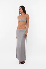 Conjunto de top con arco metálico en el busto y tiras para atar en el hombro, y panty con tiras largas para atar de forma que queden a la vista. Confeccionado en tela con brillos.