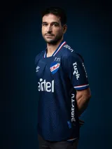 Camiseta de fútbol Umbro del Club Nacional de Football, modelo Away 2025. Diseño azul con detalles en blanco y rojo en cuello y mangas. Incluye logo de Umbro, escudo del club y sponsor Antel en el frente.
