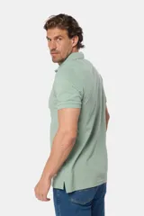 Remera polo azul de piqué liso, con cuello de rib y botones personalizados.