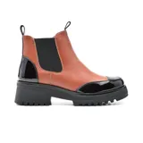 Bota Chelsea de cuero sintético negro con elástico lateral, puntera y talón charolados, plataforma track y tiradores en la caña.