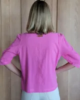 Camisa color beige claro con cuello con volados y mangas 3/4 abullonadas.