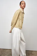 Chaqueta de mujer realizada en piel de ante color beige. Tiene cuello solapa, manga larga, bolsillos de plastrón en delantero y cierre frontal con botones.