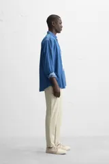 Pantalón de vestir gris oscuro, corte slim fit, con cintura elástica, bolsillos frontales y traseros de ojal.