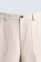 Pantalón negro de corte recto, con bolsillos frontales tipo parche y bolsillos traseros de ojal.