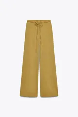 Pantalón ocre de algodón compacto, tiro medio, cintura elástica con cordón ajustable, pierna ancha y efecto lavado.