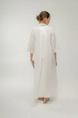 Vestido camisero azul de largo midi, con cuello mao con volados y mangas 3/4. Tiene cierre frontal con botones y un bolsillo de crochet aplicado.