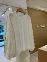 Sweater tejido negro con cuello redondo y diseño de ochos.