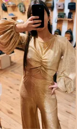 Blusa dorada de lamé elastizado, con frunce central y mangas largas abullonadas en los puños.