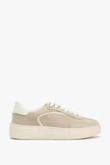 Zapatillas deportivas color beige, estilo soft, con cuerpo en combinación de materiales y cierre mediante cordones. Suela de 3 cm de altura.